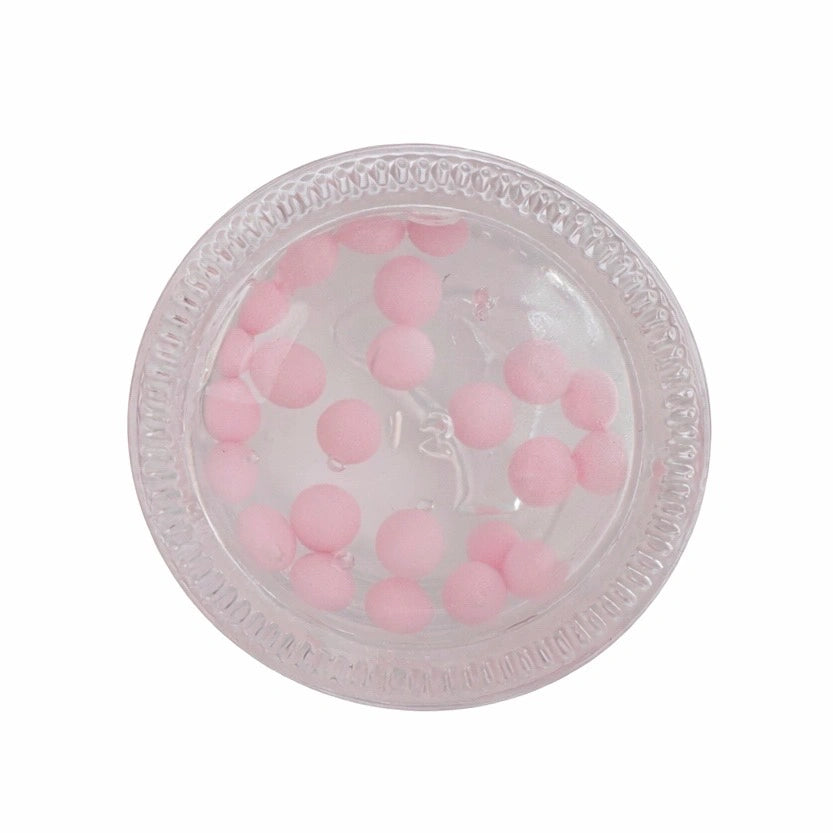 Clear plastic container with pink beads on a white background