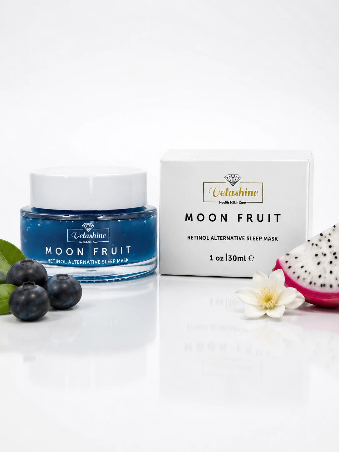 Velashine Moon Fruit Retinol Alternative Sleep Mask jar in blue with a white lid, shown next to its white product box on a white reflective surface, styled with blueberries, a dragon fruit slice, and a white flower.